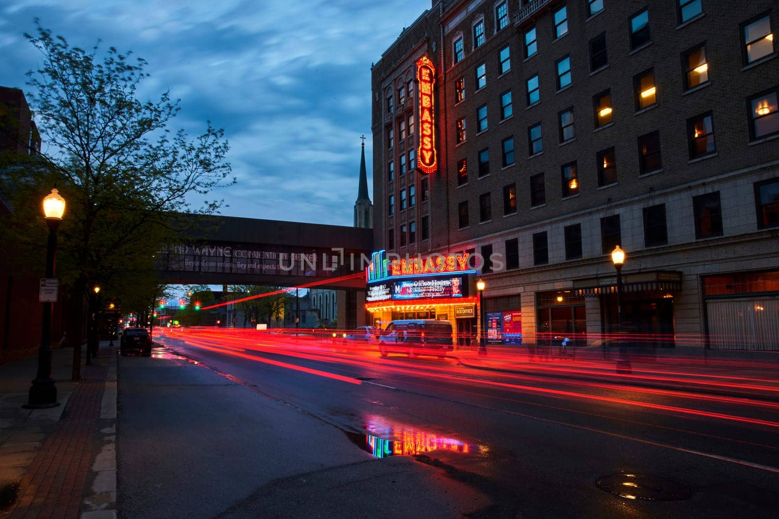 Twilight over Fort Wayne: Neon lights of Embassy Theatre illuminate a bustling downtown street.