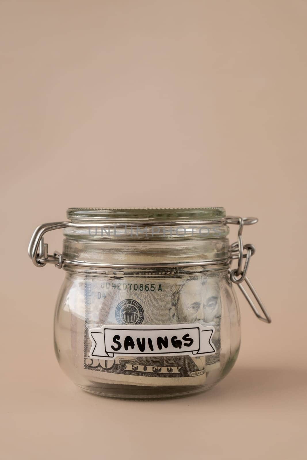Glass jar full of American currency dollars cash banknote with text SAVINGS. Preparation saving money. Moderate consumption and economy. Collecting money