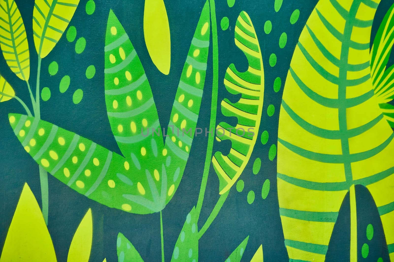 Vivid mural of intertwined tropical leaves in bold greens and yellows, capturing nature's artistry in Fort Wayne.