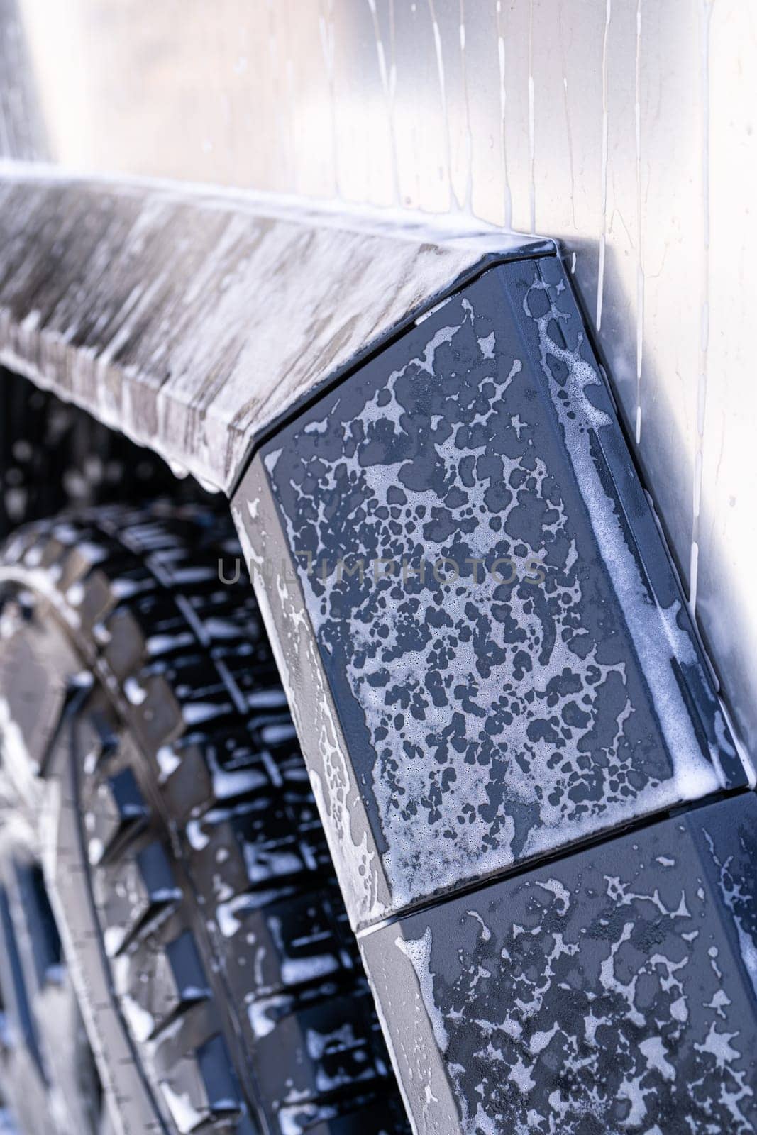 Close-up of Tesla Cybertruck Wheel and Body Covered in Soap by arinahabich