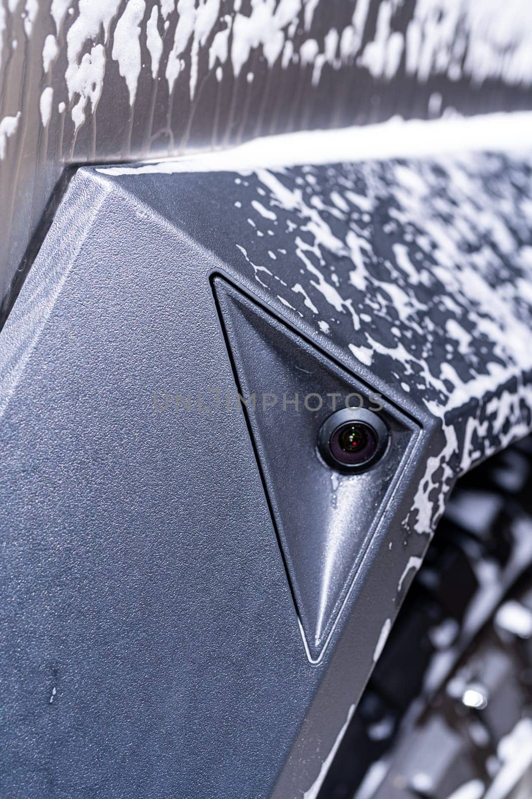 Denver, Colorado, USA-May 5, 2024-This image captures a close-up view of a side camera on the Tesla Cybertruck, covered in soap suds during a cleaning session, emphasizing the vehicle sleek design and modern features.