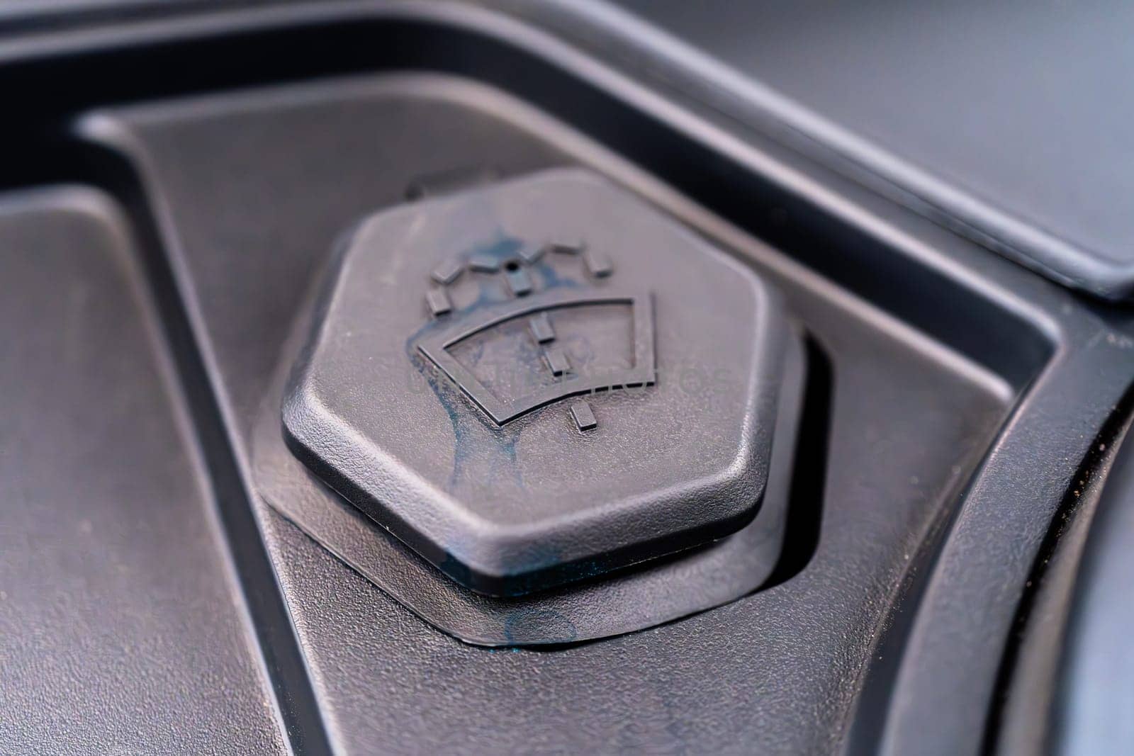 Denver, Colorado, USA-May 5, 2024-This image shows a detailed close-up of the windshield washer fluid cap in a Tesla Cybertruck, highlighting the unique design and branding elements typical of Tesla innovative approach to car manufacturing.