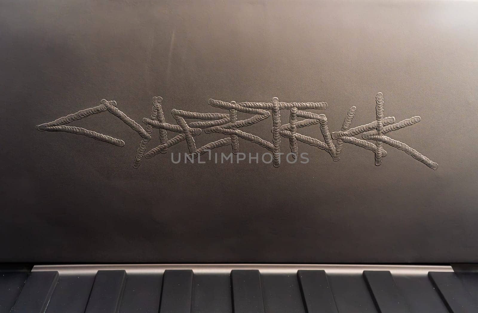 Engraved Logo Detail Inside the Open Frunk of a Tesla Cybertruck by arinahabich