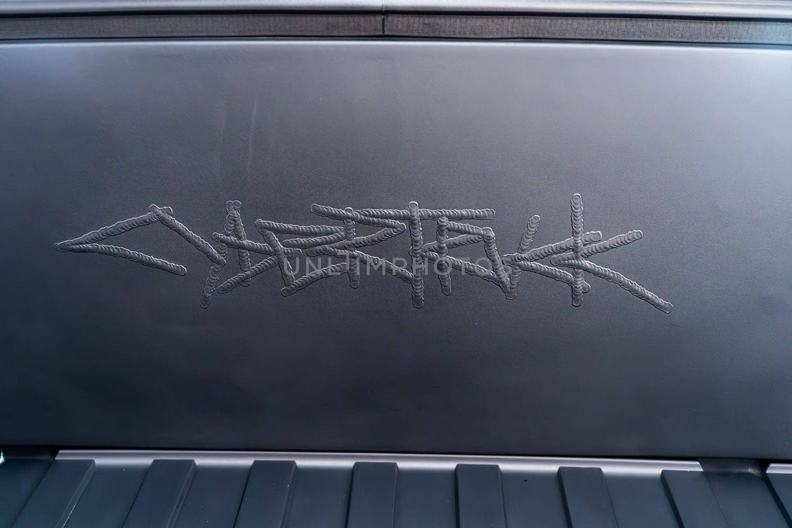 Engraved Logo Detail Inside the Open Frunk of a Tesla Cybertruck by arinahabich