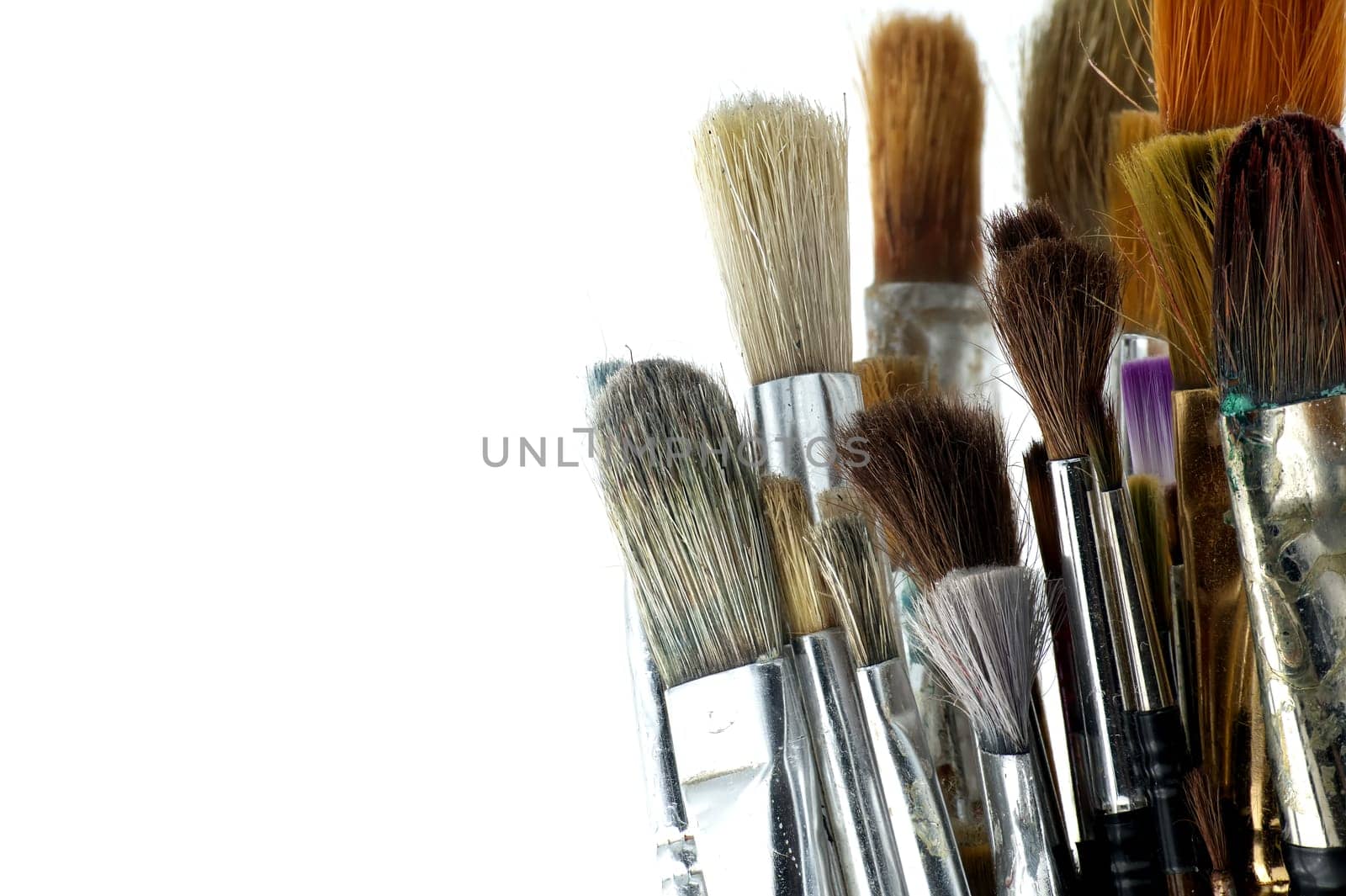 Array of paintbrushes of different sizes and colors isolated on white background