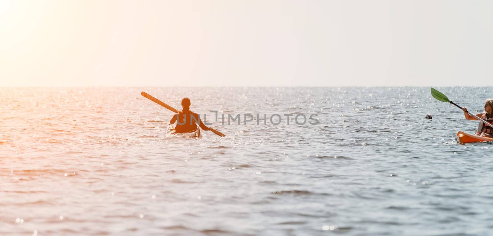 Woman sea kayak. Happy smiling woman in kayak on ocean, paddling with wooden oar. Calm sea water and horizon in background. Active lifestyle at sea. Summer vacation. by panophotograph