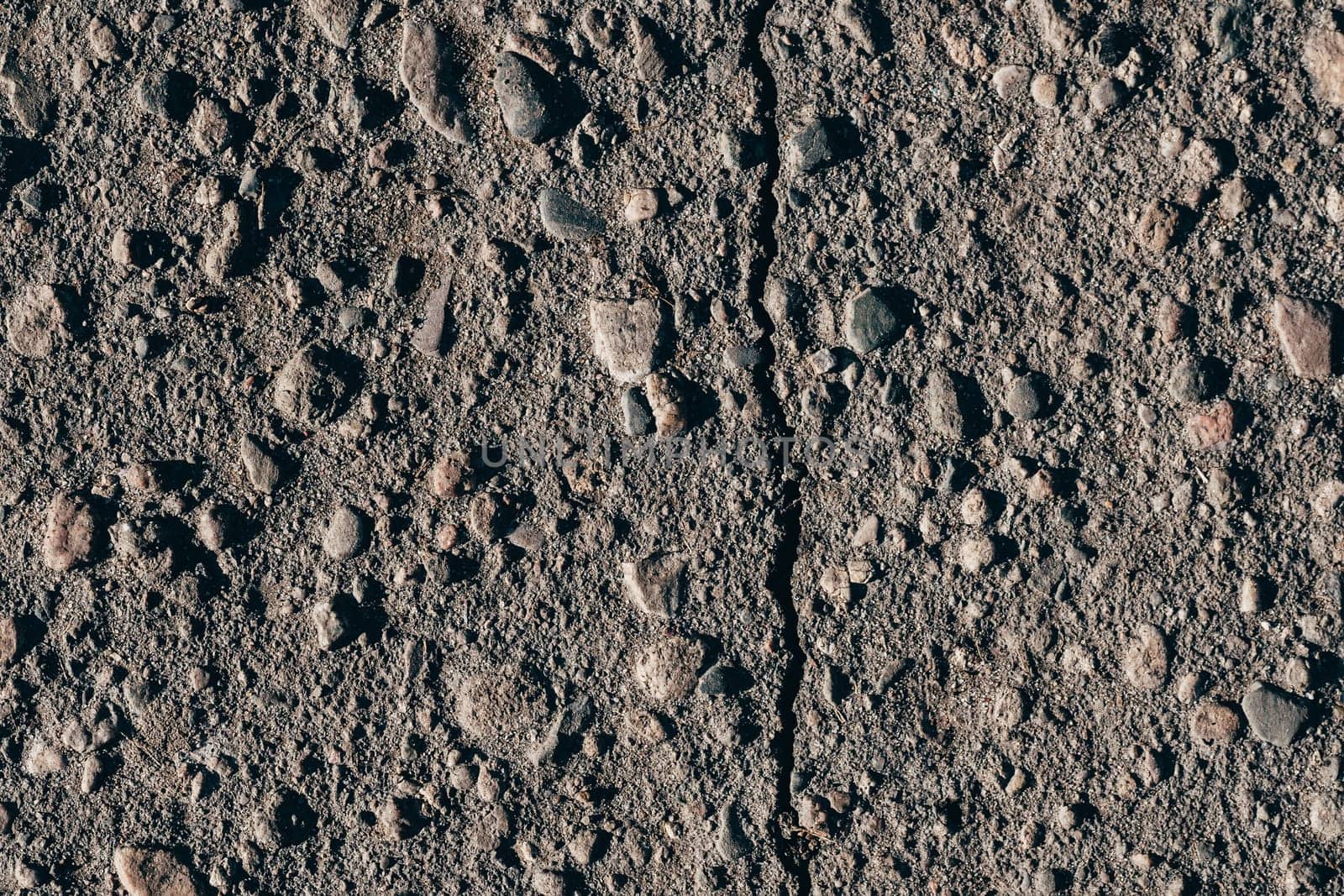 texture of dirty old asphalt with stones close-up