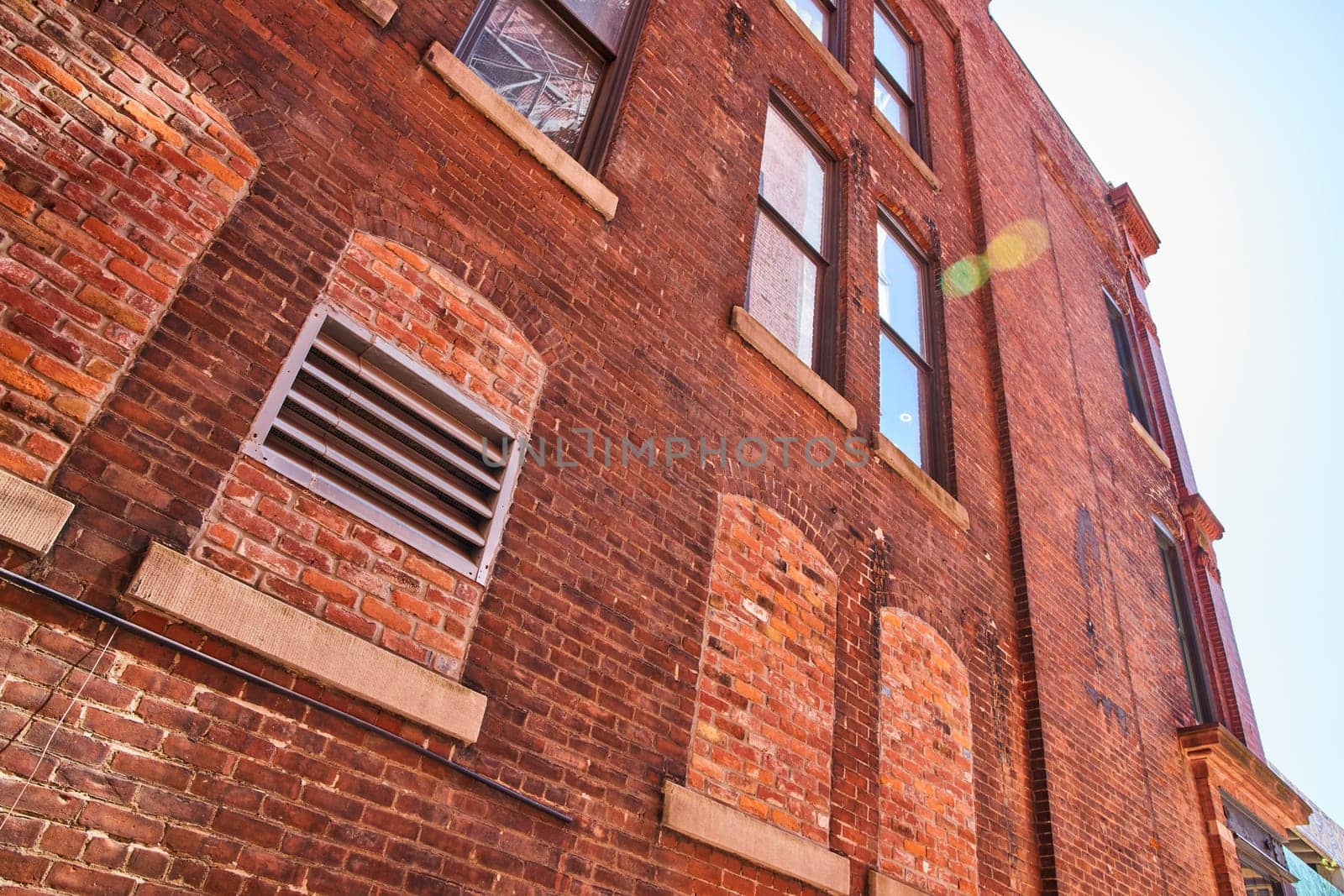 Sunlit vintage brick facade in downtown Fort Wayne, highlighting urban architecture and historical charm.