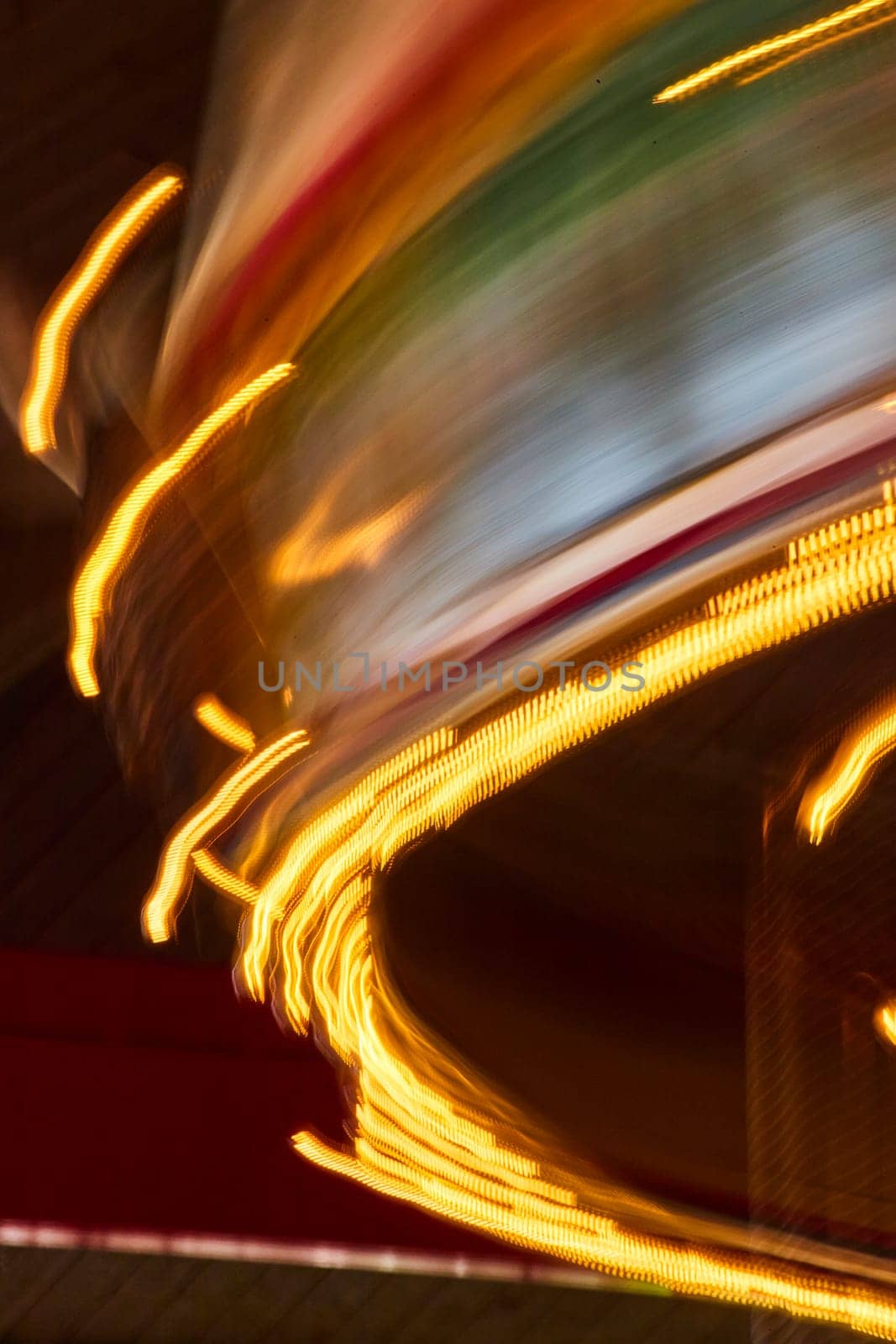 Vivid streaks of yellow and red lights capture the thrill of a carousel ride at night at the Fort Wayne Children's Zoo.