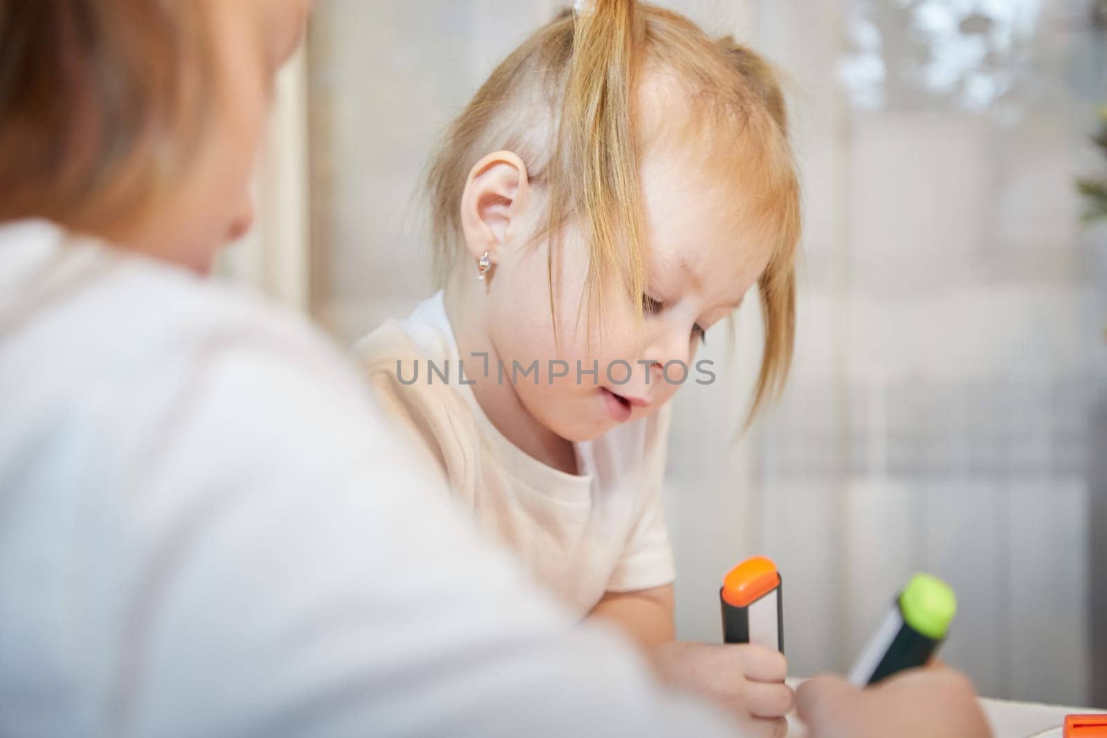 Cute little sisters are painting on table. Preschooler, 4 and 8 years child in living room. Small girl kids doing homework. Home schooling concept by keleny