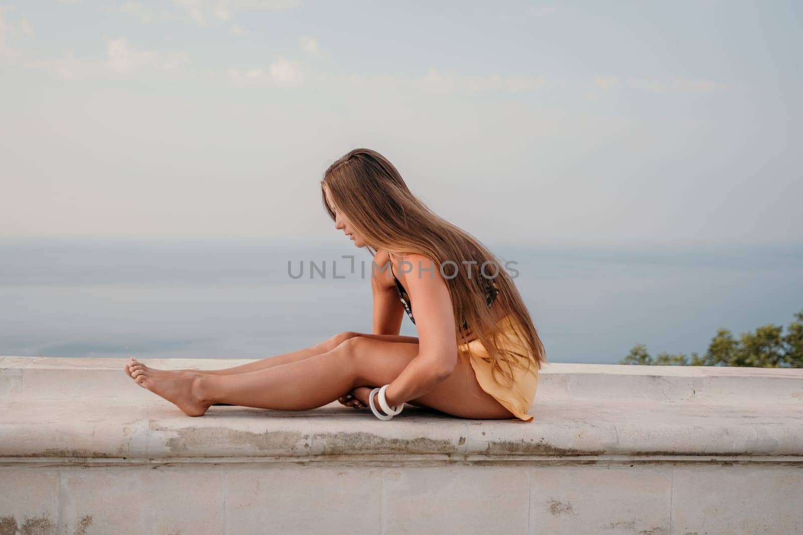Woman park yoga. Side view of free calm bliss satisfied woman with long hair standing in morning park with yoga position against of sky by the sea. Healthy lifestyle outdoors in park, fitness concept