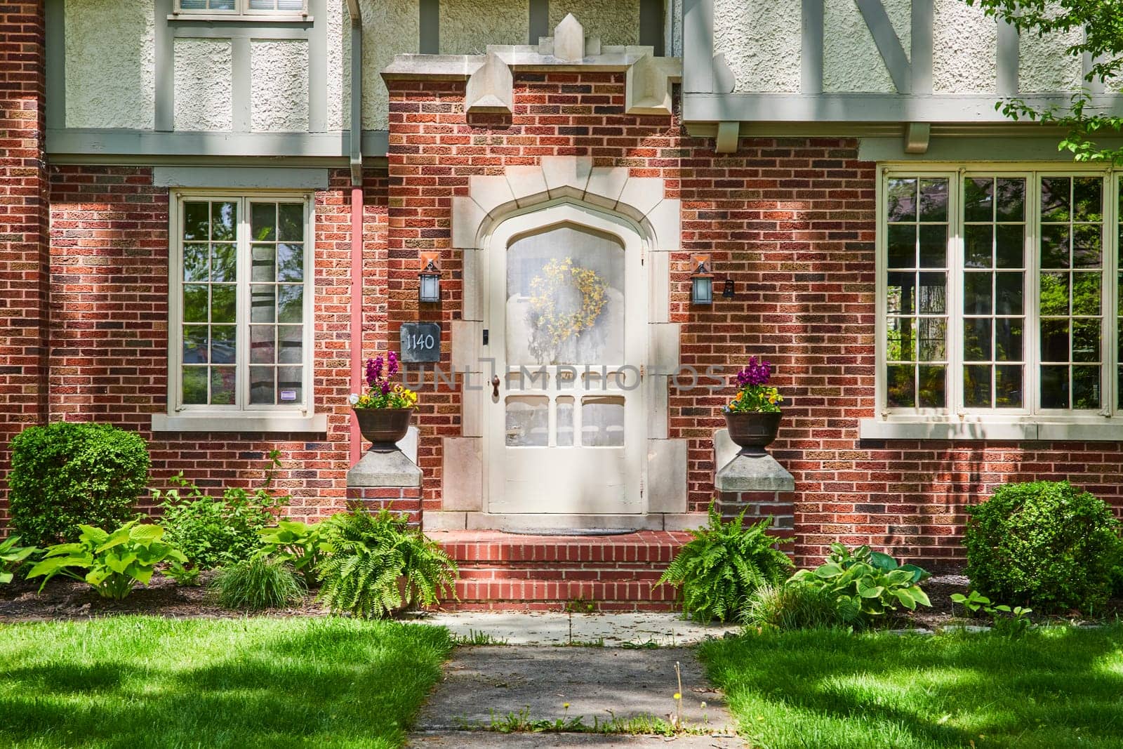 Traditional brick home in South Wayne Historic District, Fort Wayne, with vibrant floral entryway.