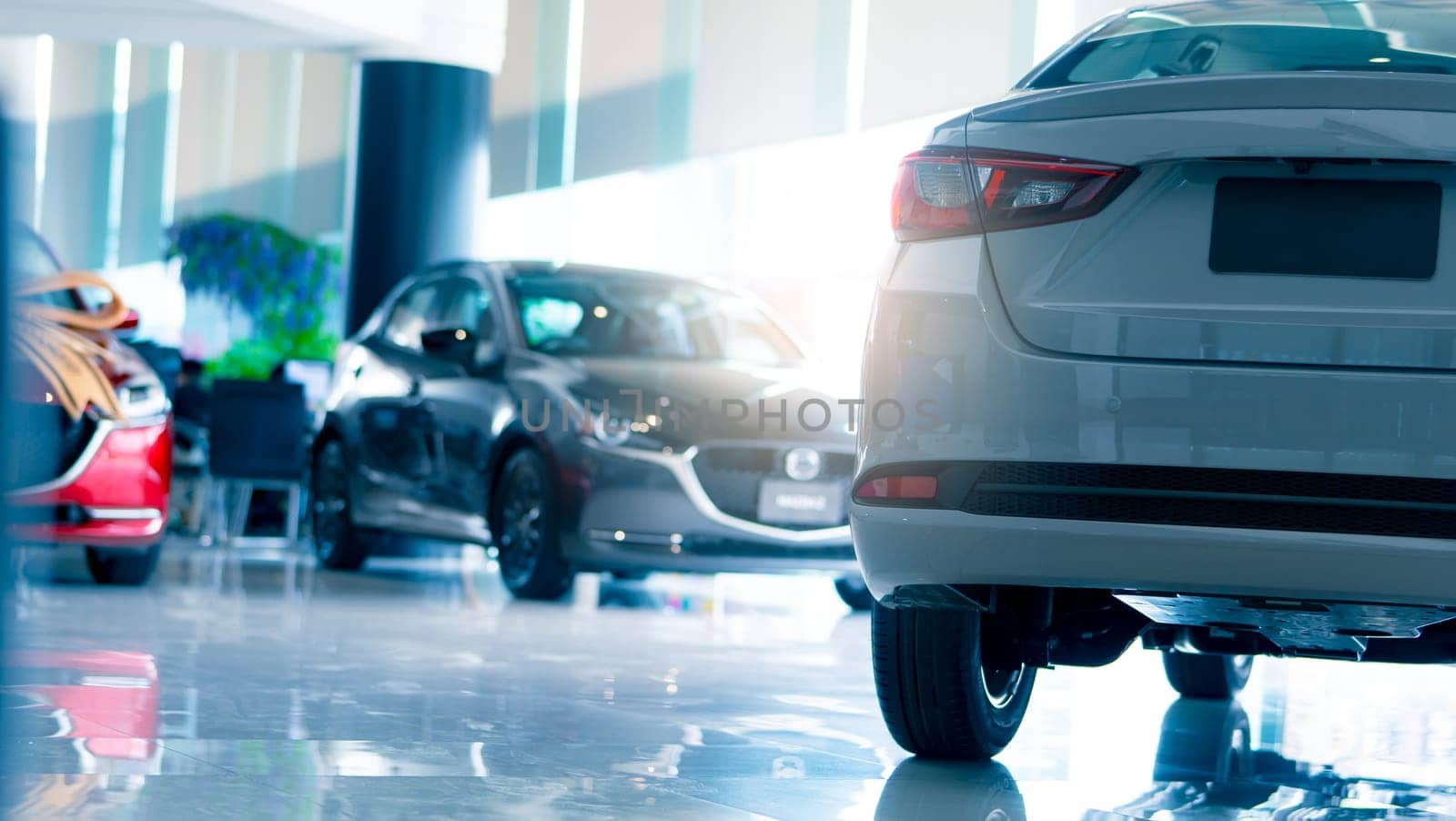 Selective focus car parked in luxury showroom. Car dealership office. New car parked in modern showroom. Car for sale and rent business concept. Automobile leasing and insurance background.