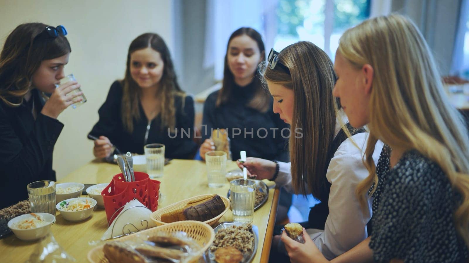 Senior girls having breakfast in the school canteen. by DovidPro