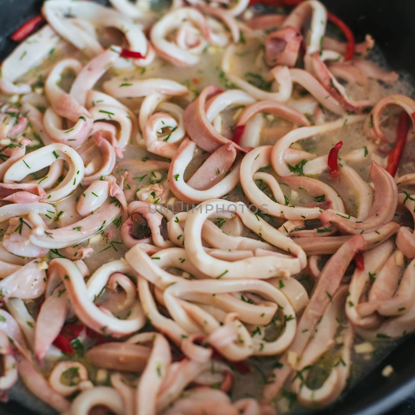 Squid rings are stewed in a pan for a delicious dinner