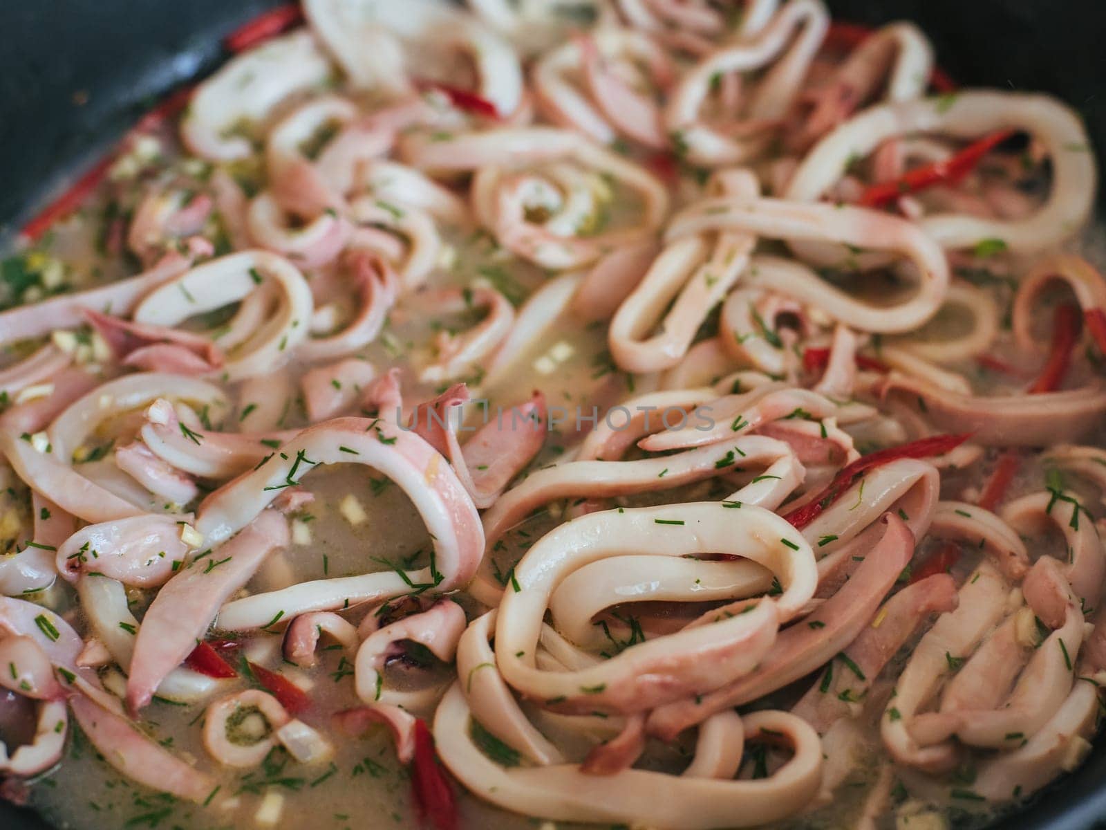 Squid rings are stewed in a pan for a delicious dinner