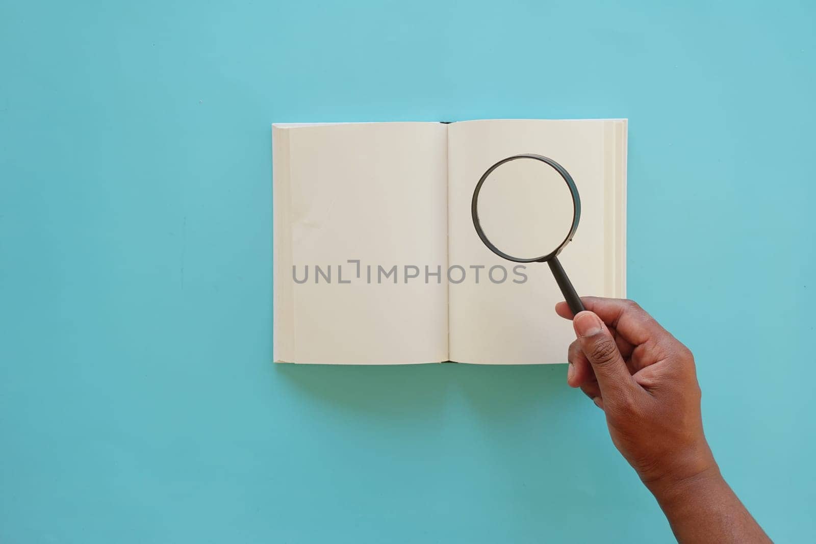 open book and magnifying glass on table