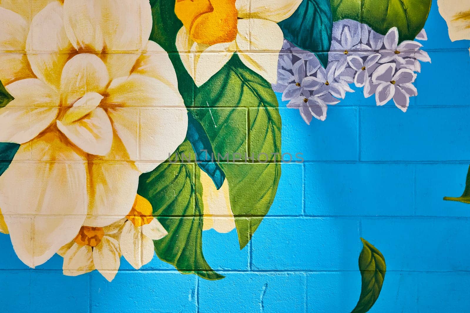 Vibrant floral mural on a blue brick wall in downtown Fort Wayne, adding color and life to the urban space.