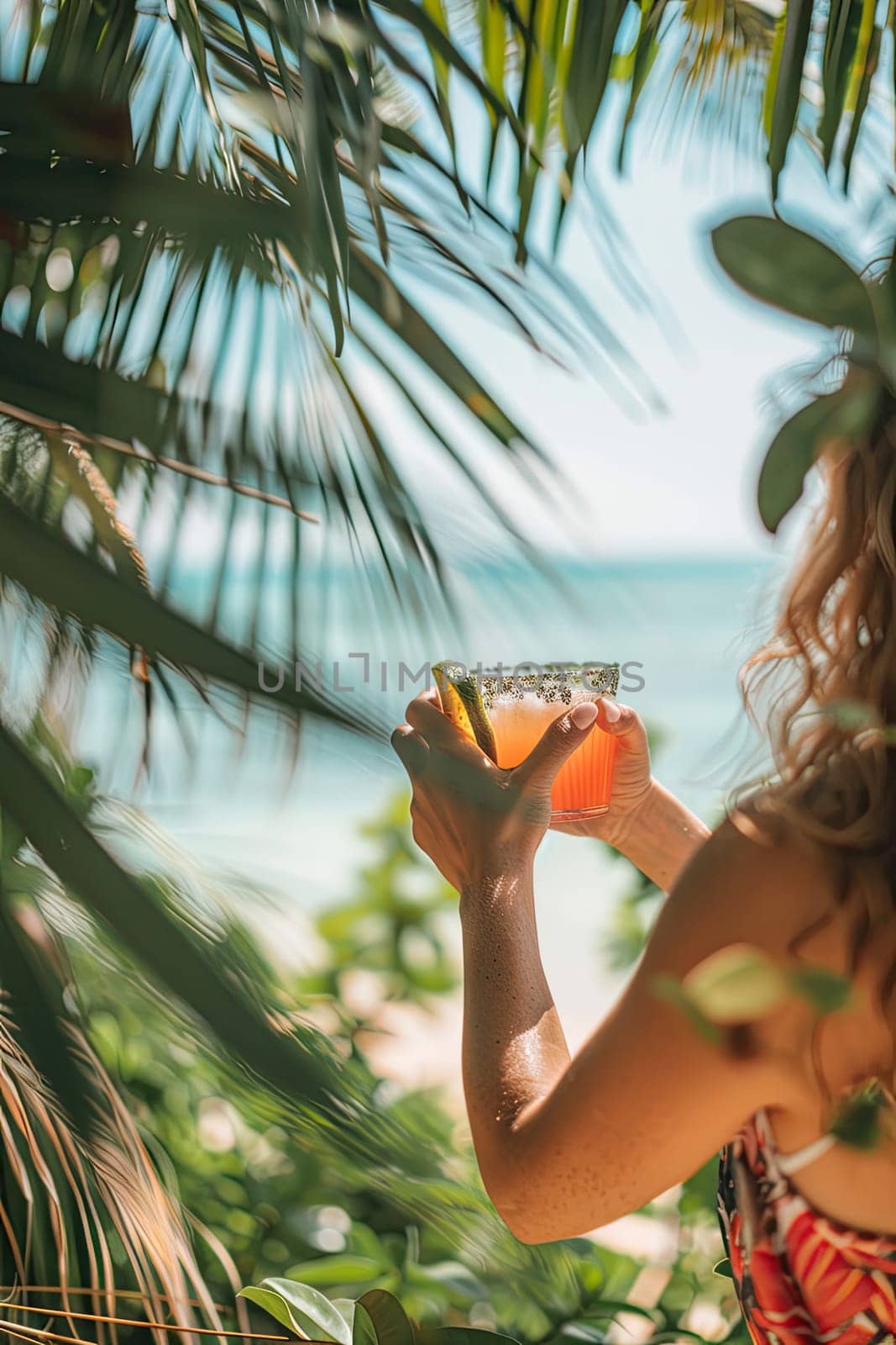 A cocktail in the hands of a girl on the beach. Selective focus. by yanadjana