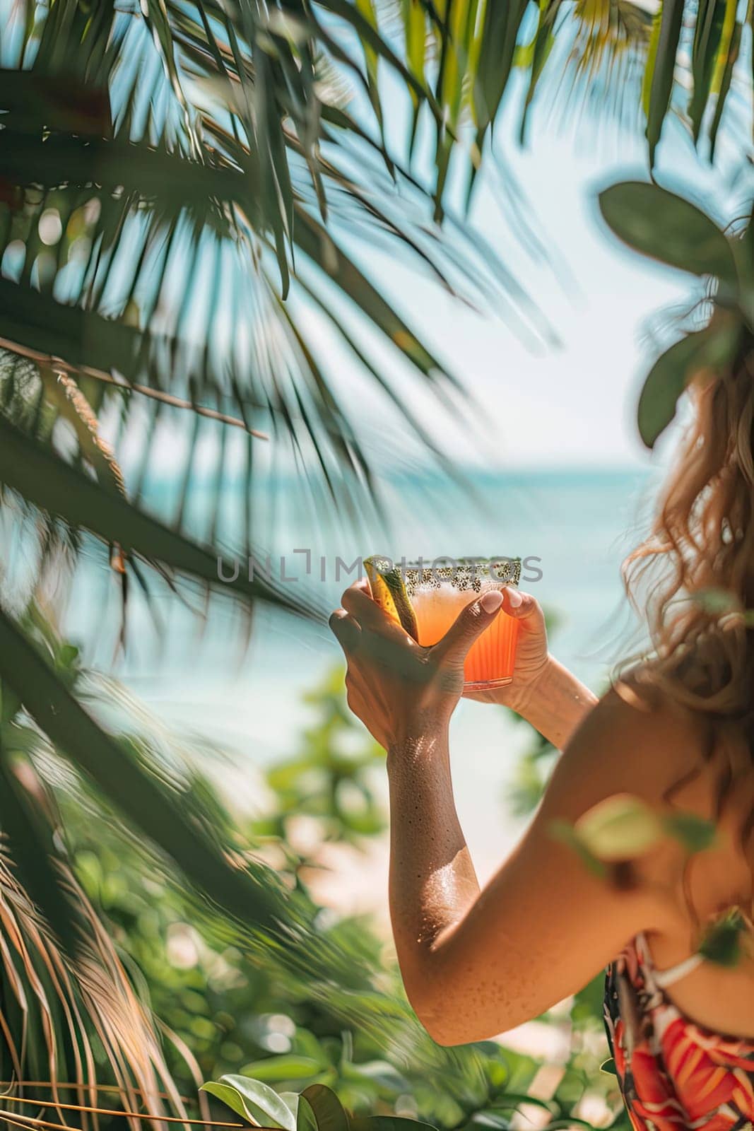 A cocktail in the hands of a girl on the beach. Selective focus. Drink.