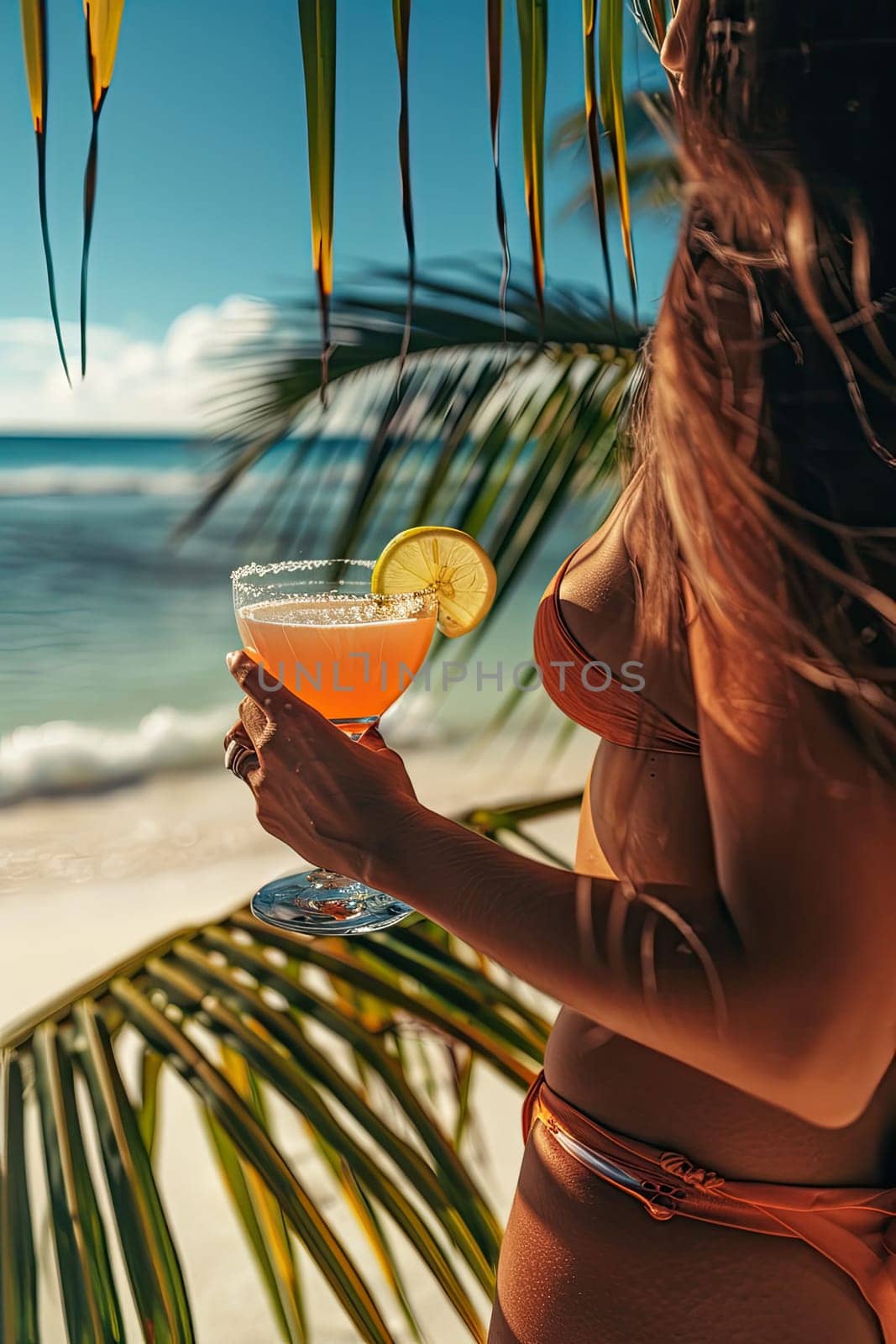 A cocktail in the hands of a girl on the beach. Selective focus. Drink.