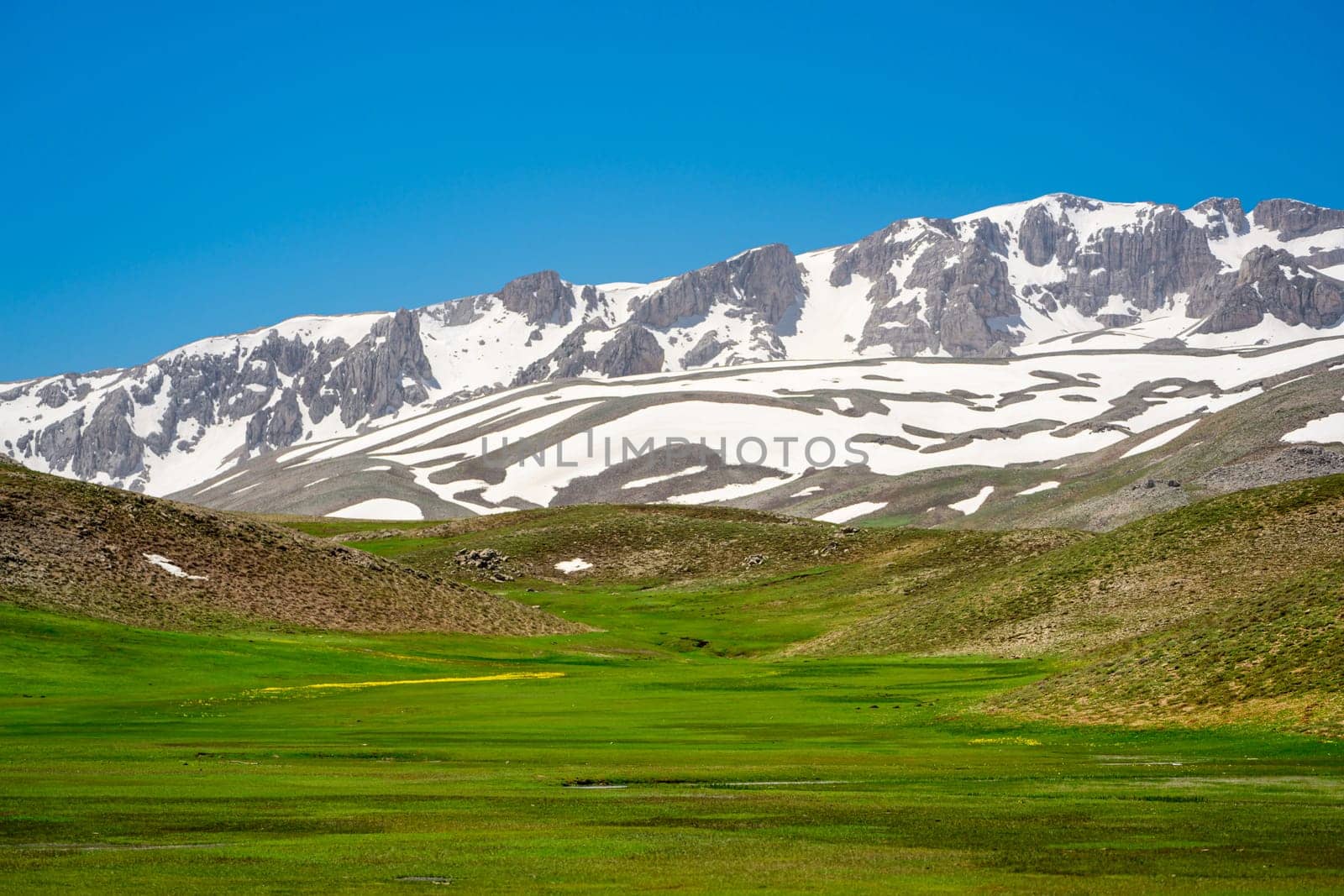 The lush green Sobucimen plateau in spring and the mountains with some melted snow behind. by Sonat