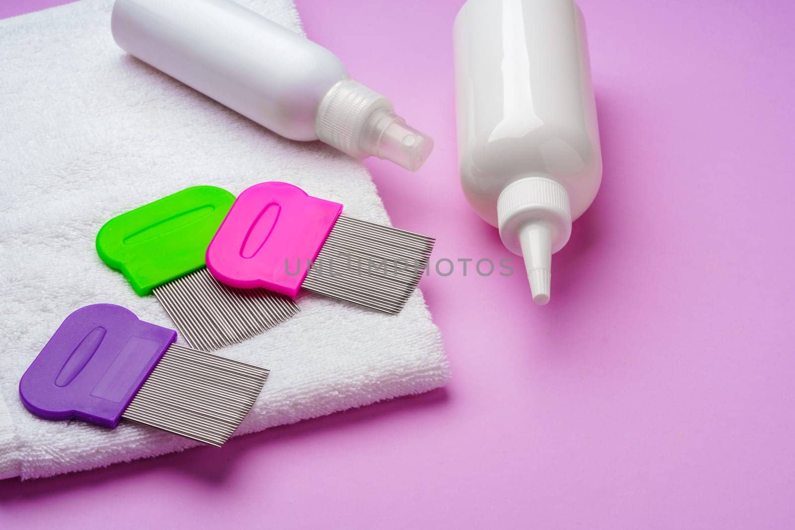 Anti lice combs and towel on pink background by Fabrikasimf