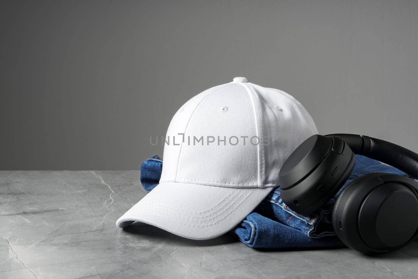 Baseball cap with black headphones on dark background studio shot