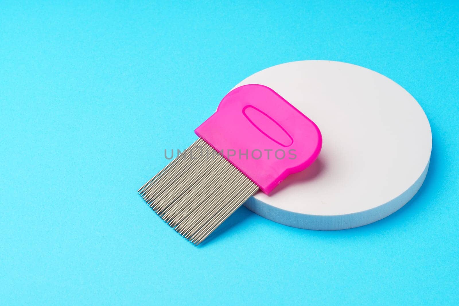 Comb for lice removing on blue background by Fabrikasimf