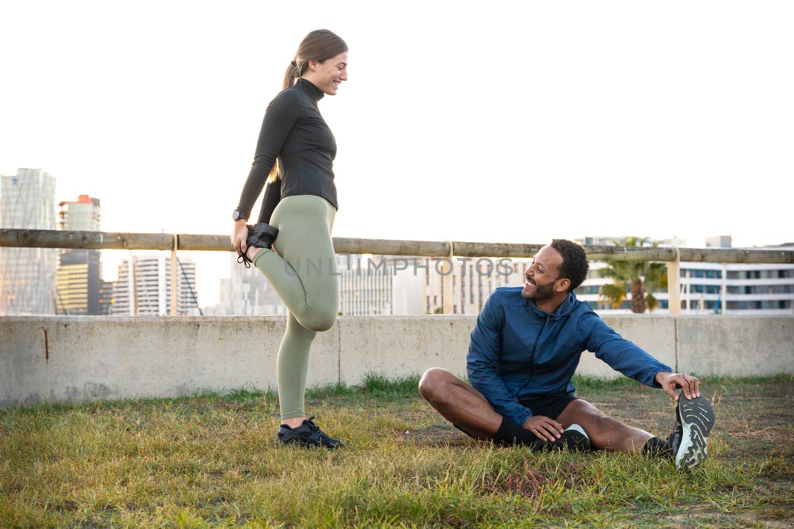 Young smiling sporty couple doing stretching. by mariaphoto3