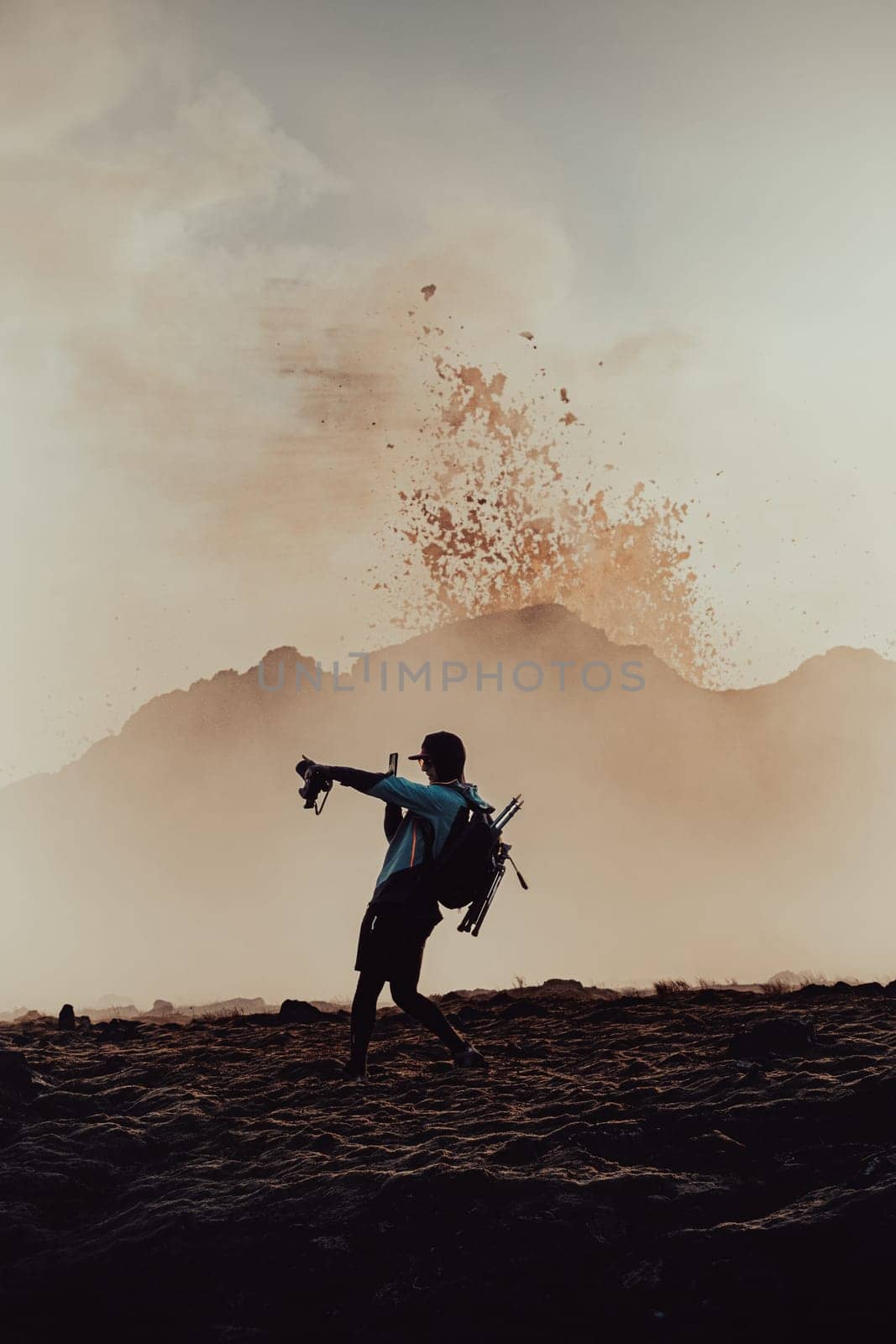 A photographer-hiker shooting with a phone under the erupting volcano in Iceland. by Kustov