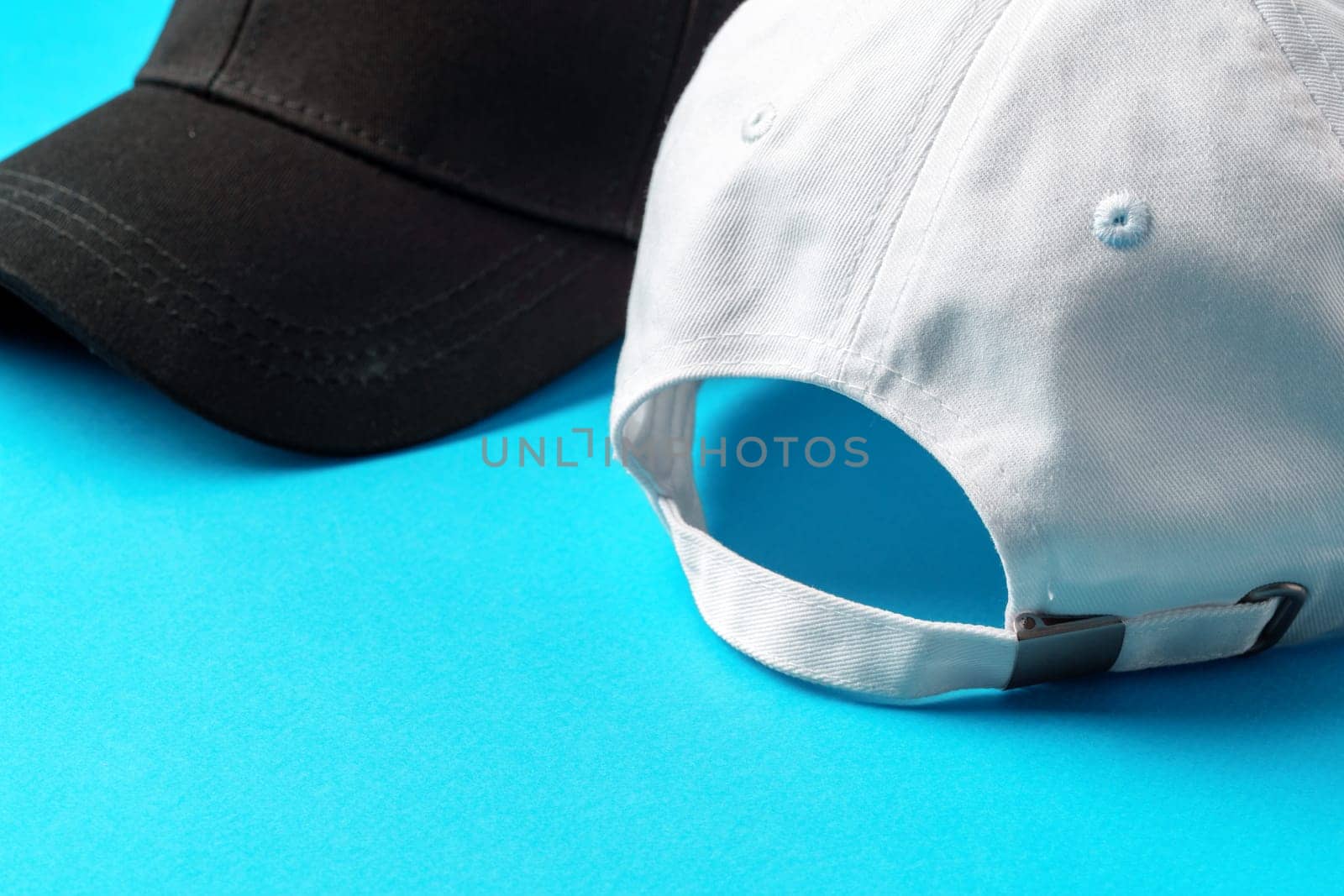 Baseball caps on blue background studio shot close up