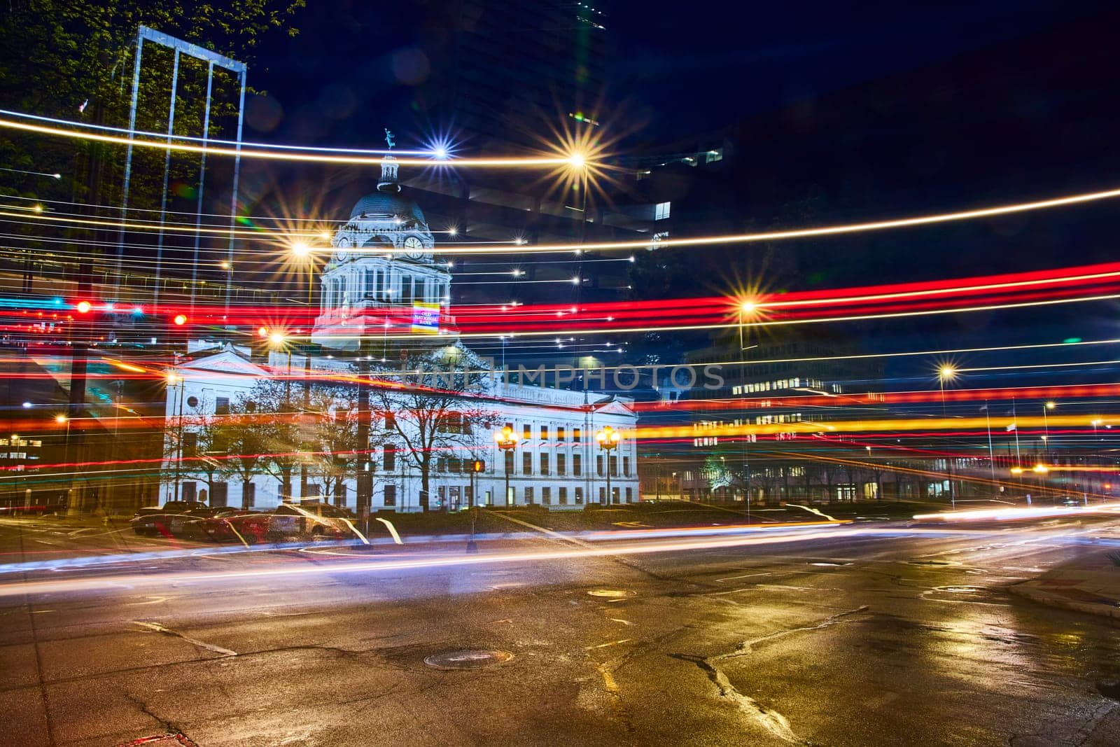 Vibrant night scene at Fort Wayne's historic courthouse, capturing the dynamic blur of city traffic.