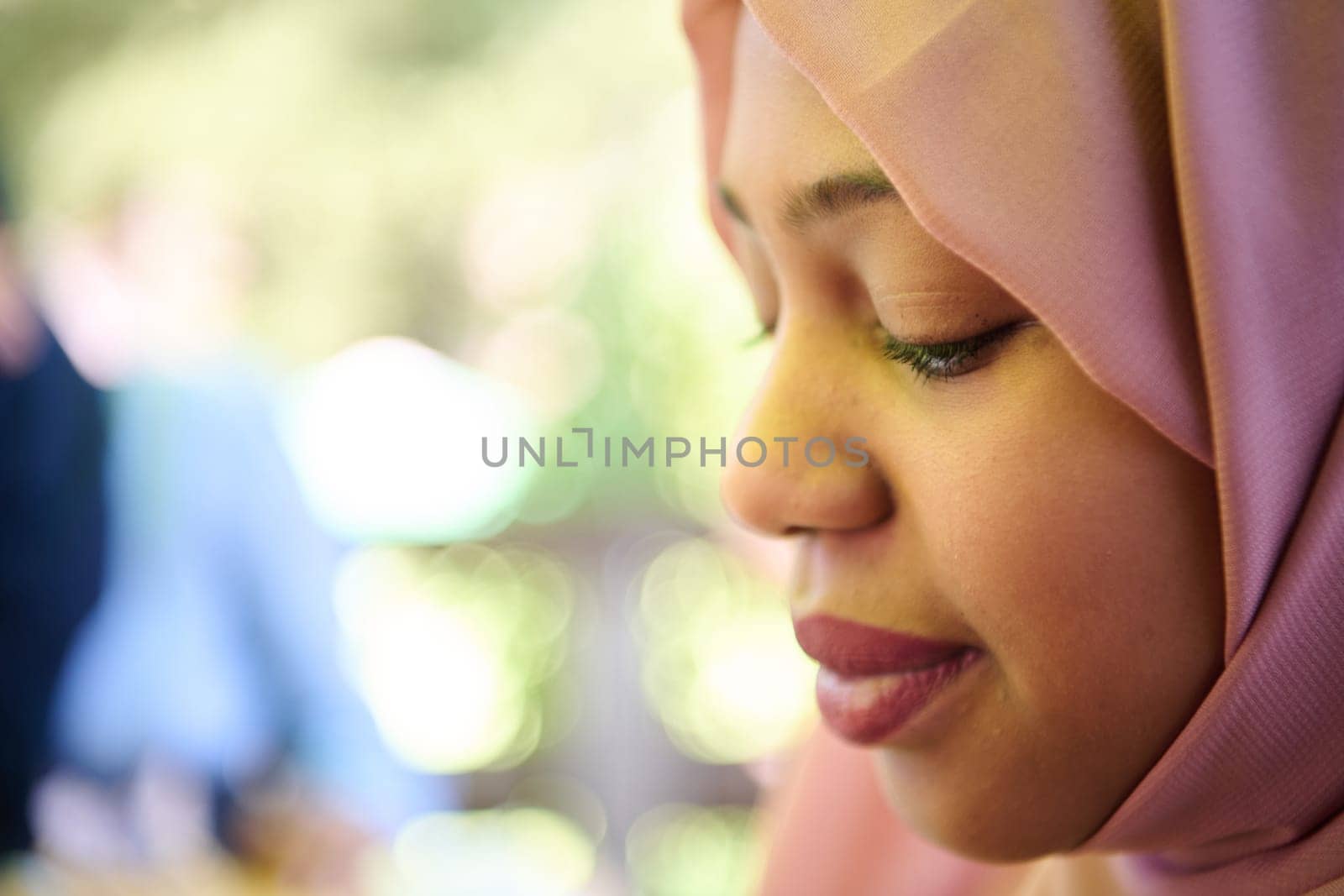 A Middle Eastern girl wearing a hijab, with a bright smile and a pink headscarf, captured in a close-up portrait exuding joy and positivity.