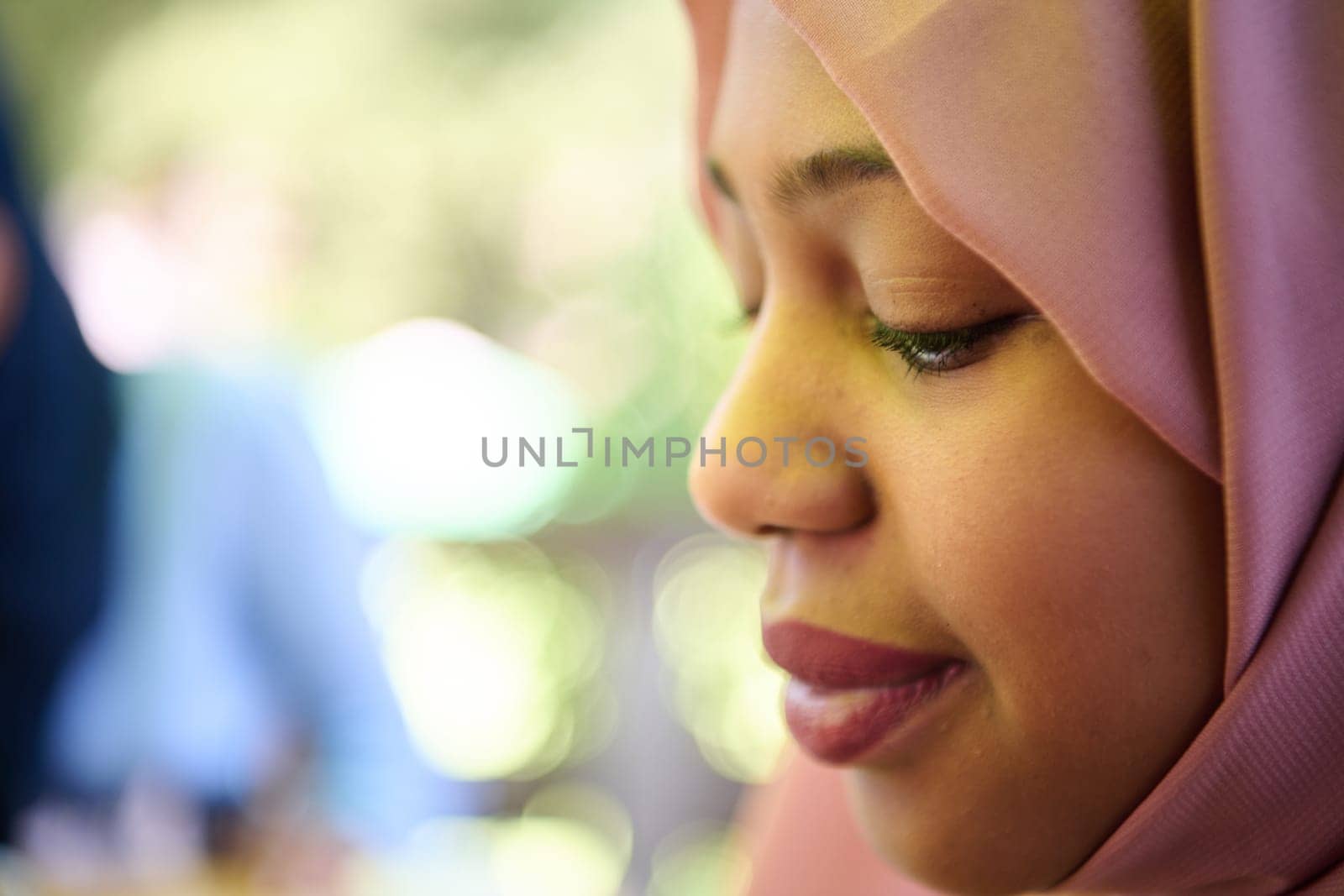 A Middle Eastern girl wearing a hijab, with a bright smile and a pink headscarf, captured in a close-up portrait exuding joy and positivity.