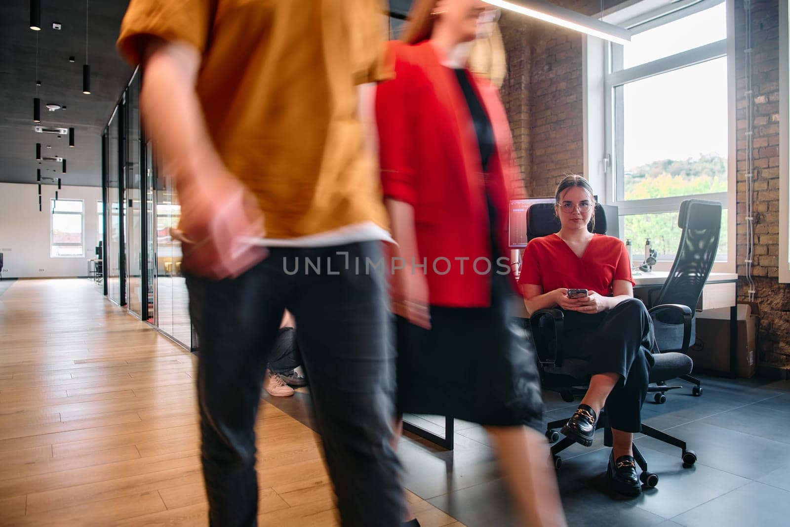 A diverse group of business professionals collaborates in a modern startup coworking center, utilizing a mix of paper-based and technological tools such as mobile phones and computers .