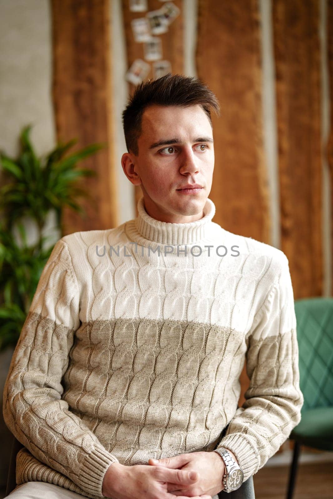 Man Sitting in Chair Wearing Sweater by Fabrikasimf
