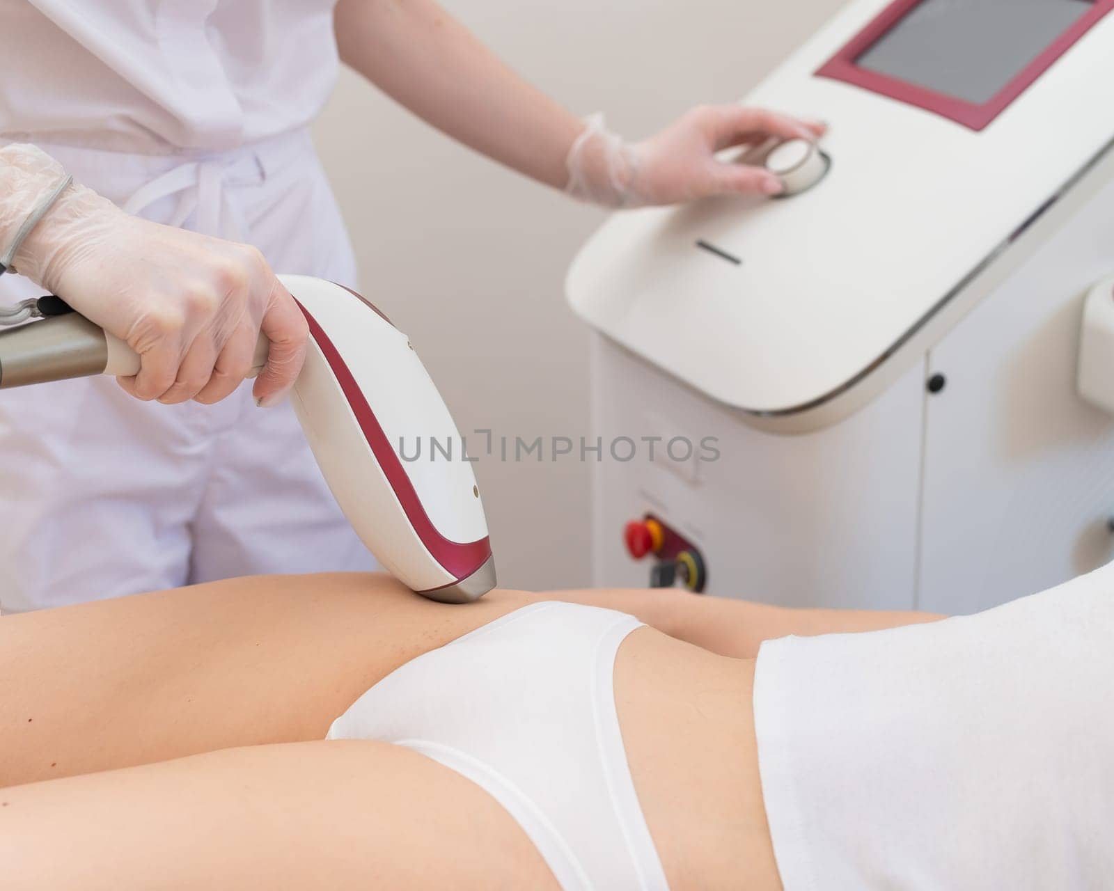 A woman in a professional beauty salon removes unwanted vegetation in the bikini area using laser hair removal.