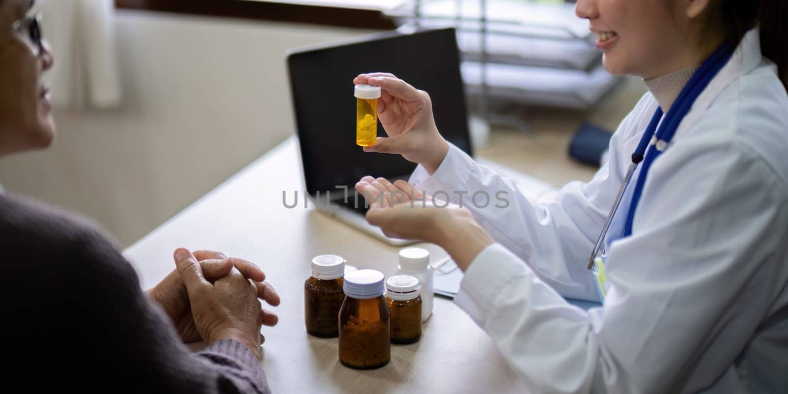 Young woman doctor sit work desk with senior old man patient prescribe drugs or pills, female nurse explain daily dosage of prescribed medicine to elderly man, elderly healthcare concept.