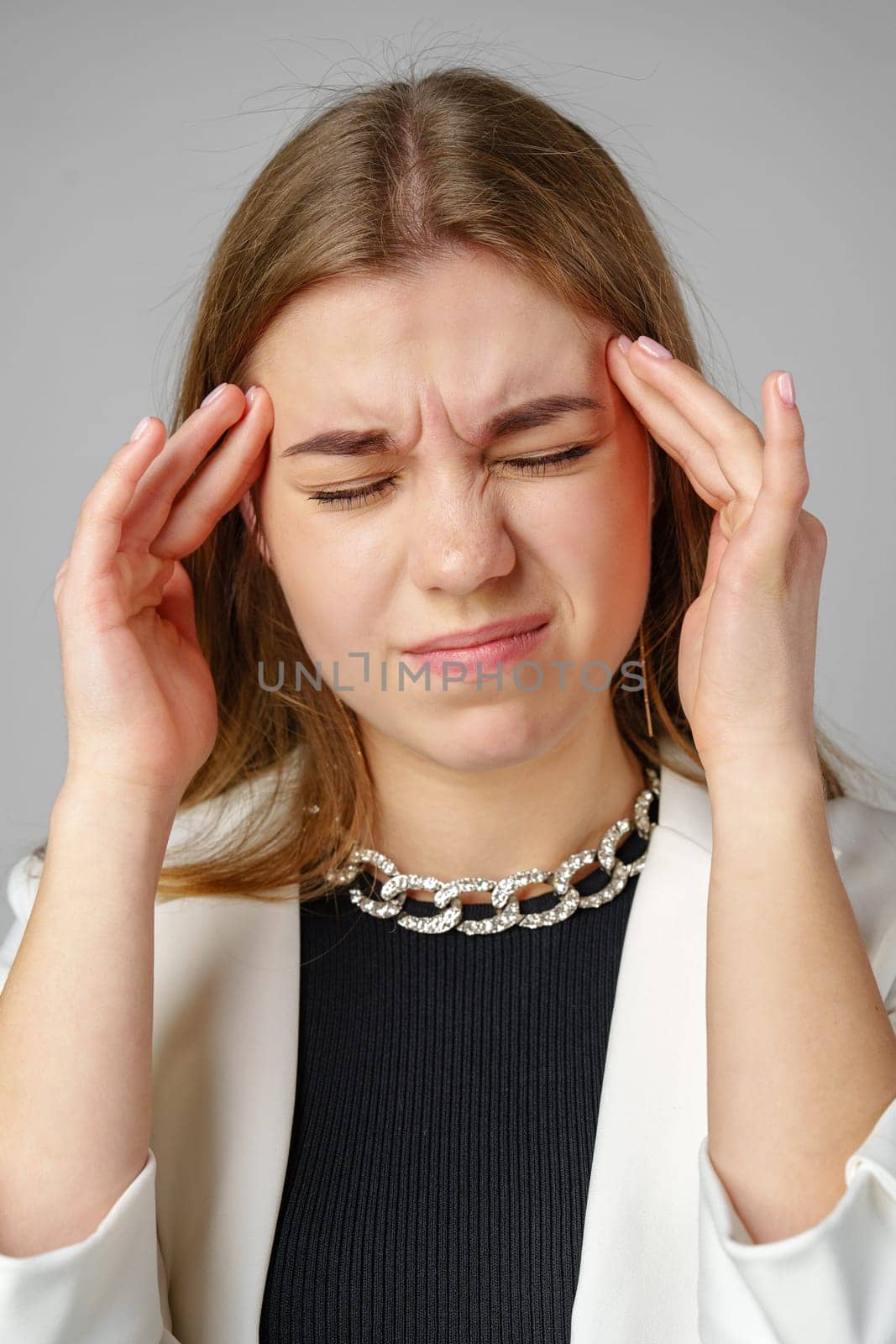 Woman Holding Her Head in Hands in Studio close up