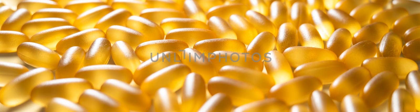 Close-up of golden omega three capsules. Dietary supplement fish oil. Widescreen.