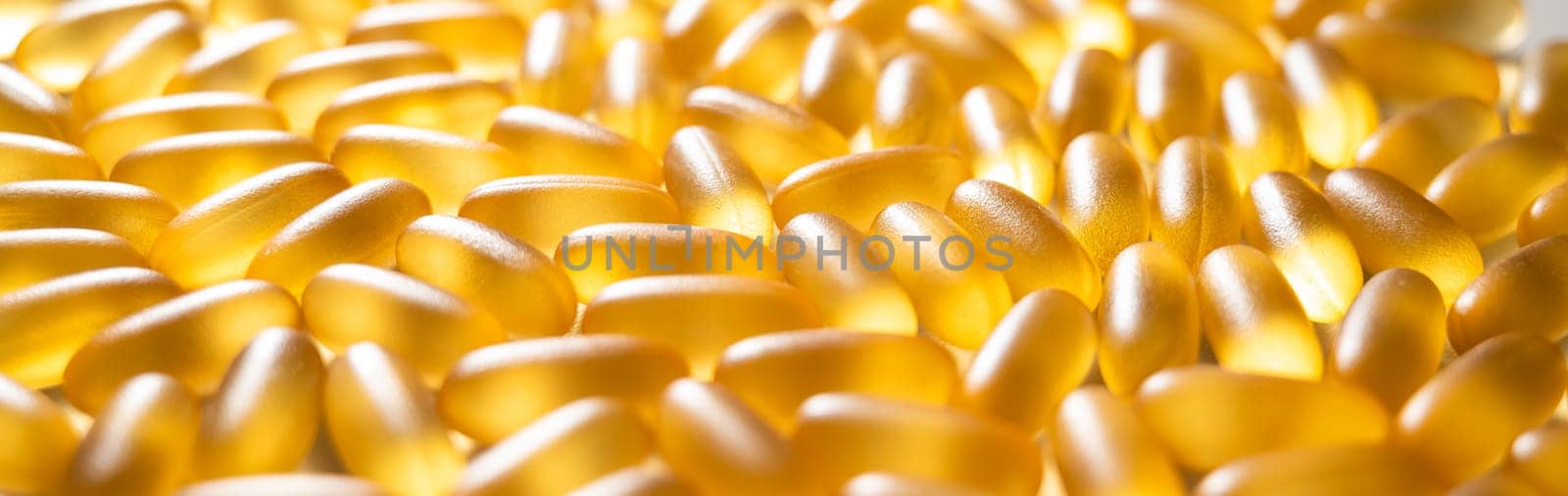 Close-up of golden omega three capsules. Dietary supplement fish oil.