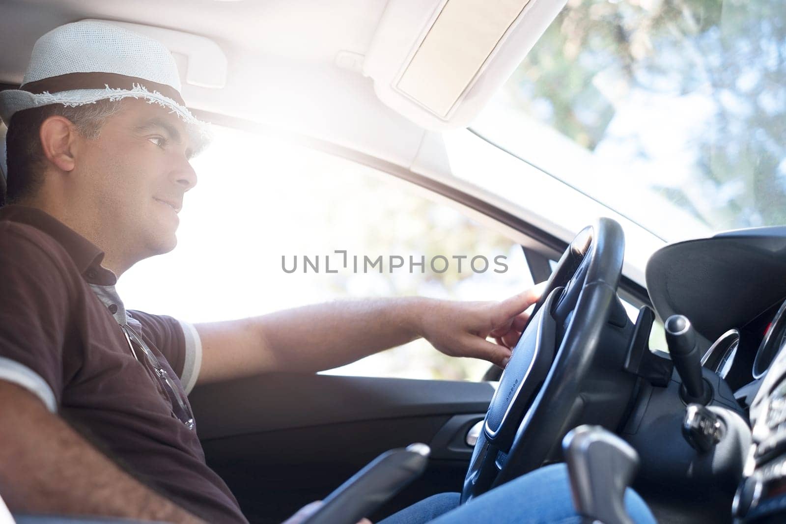 Happy young man enjoying freedom on summer vacation driving a car. Travel concept