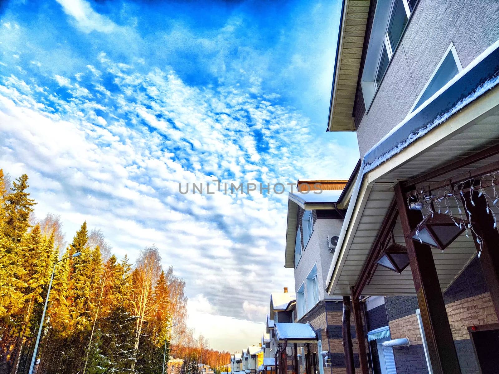 Suburban Street View With Striking Clouds at Dusk. Residential houses under a vibrant evening sky with textured clouds by keleny