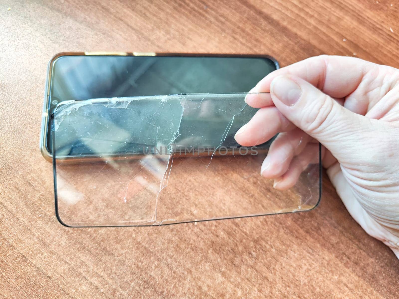 Removing Protective Film From Cracked Screen. Peeling off a cracked screen protector from a phone