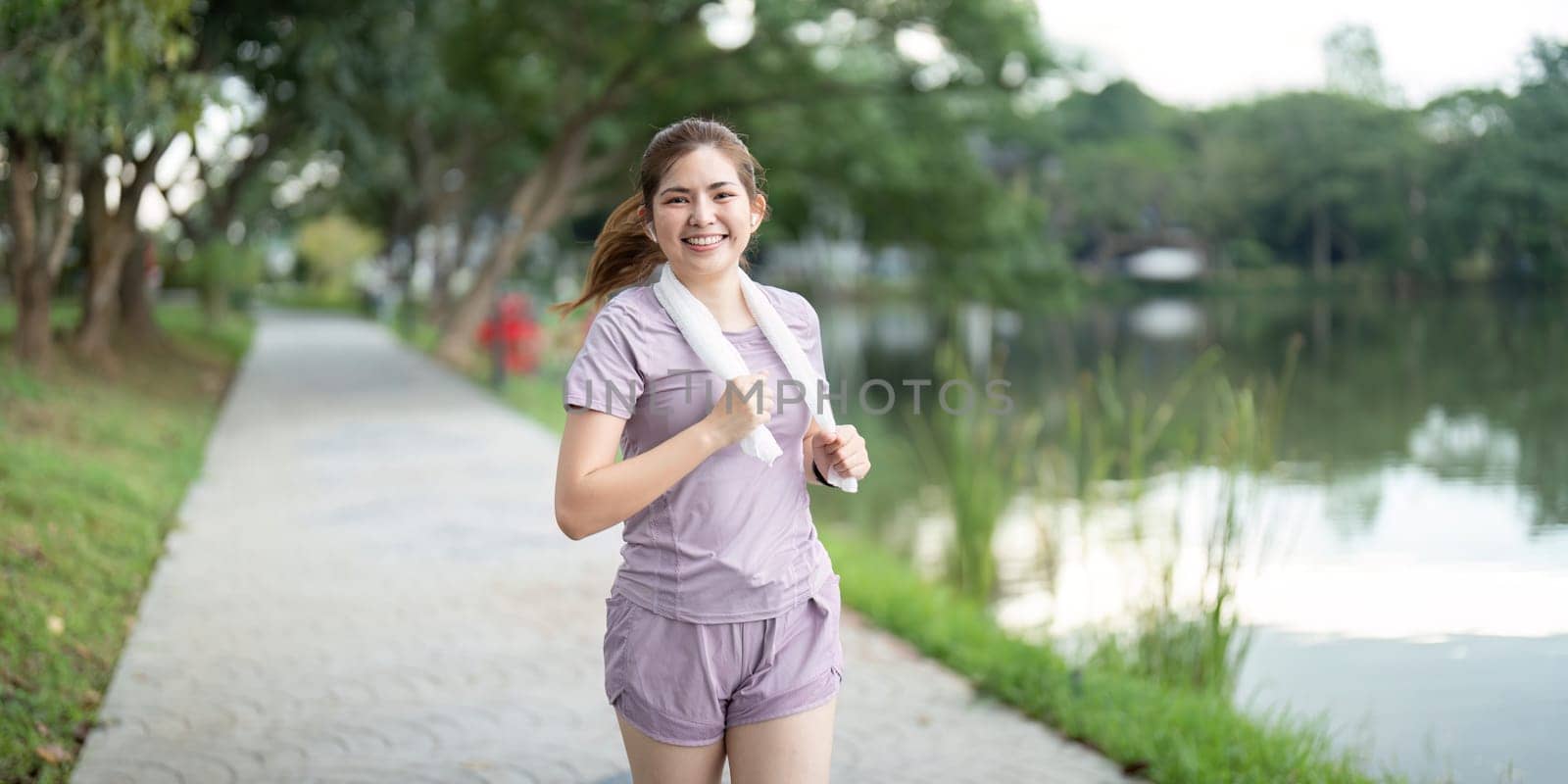 Young asian woman enjoying a morning run in a park. Workout exercise in the morning. Healthy and active lifestyle concept.