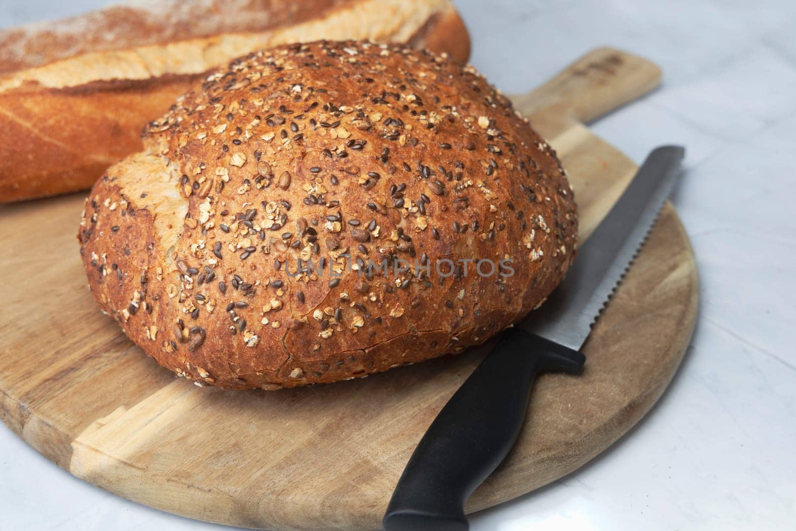 Round freshly oat baked bread on a cutting board. High quality photo