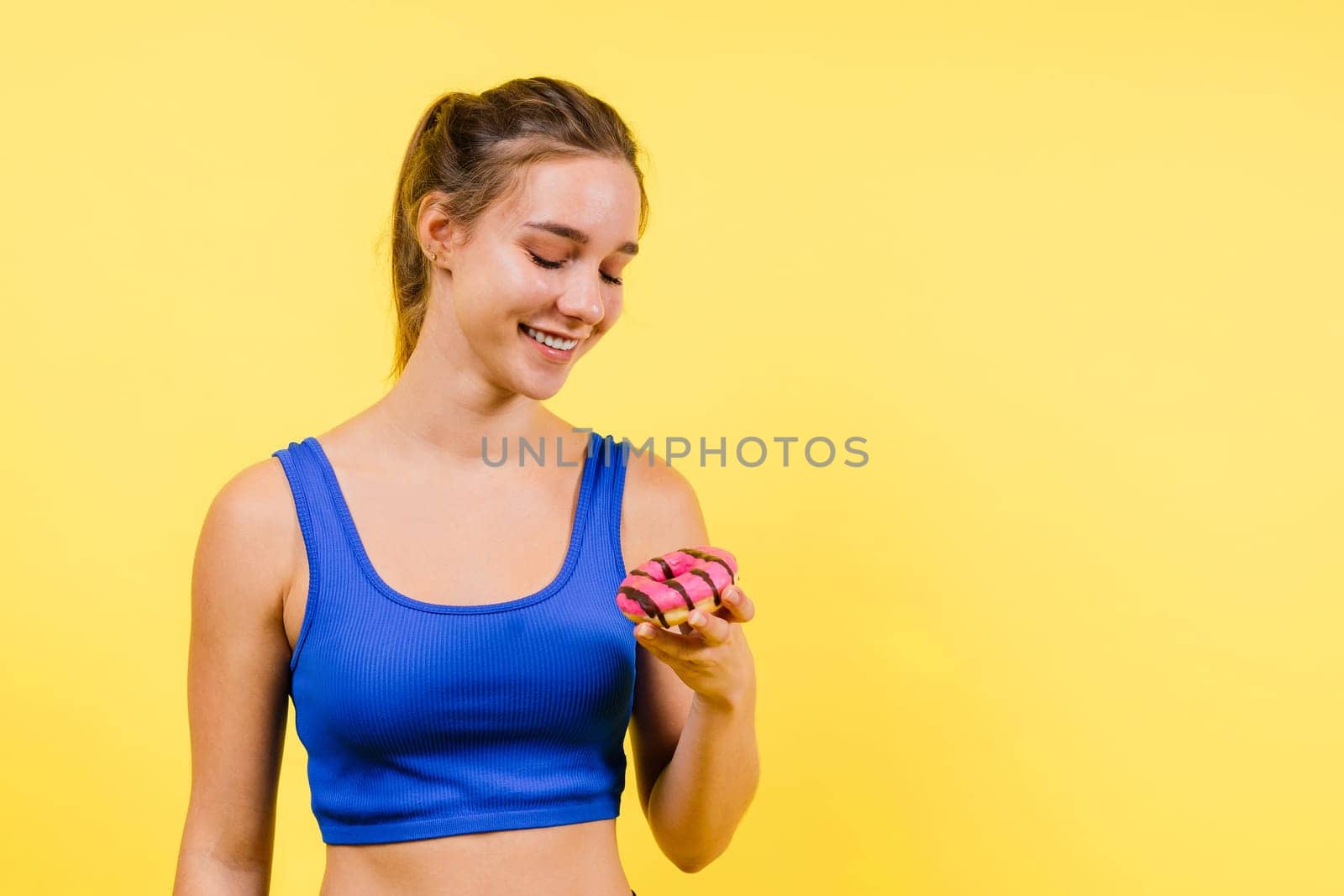 Portrait of beautiful female with chocolate donuts enjoying and looking at the camera