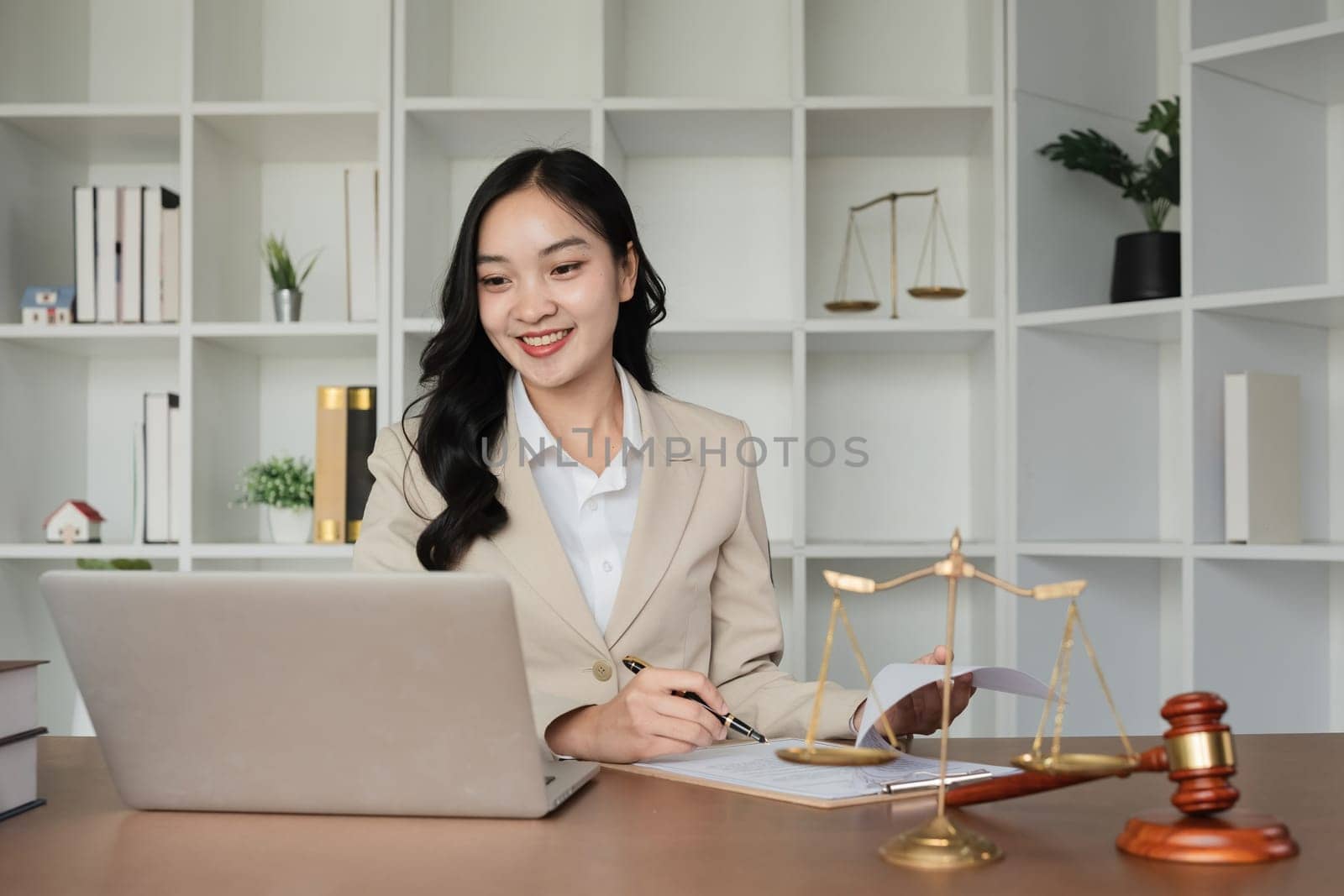 Asian female lawyer reviews online business and real estate law Legal advisors provide legal advice and guidance online via laptops in the lawyer's office. by wichayada