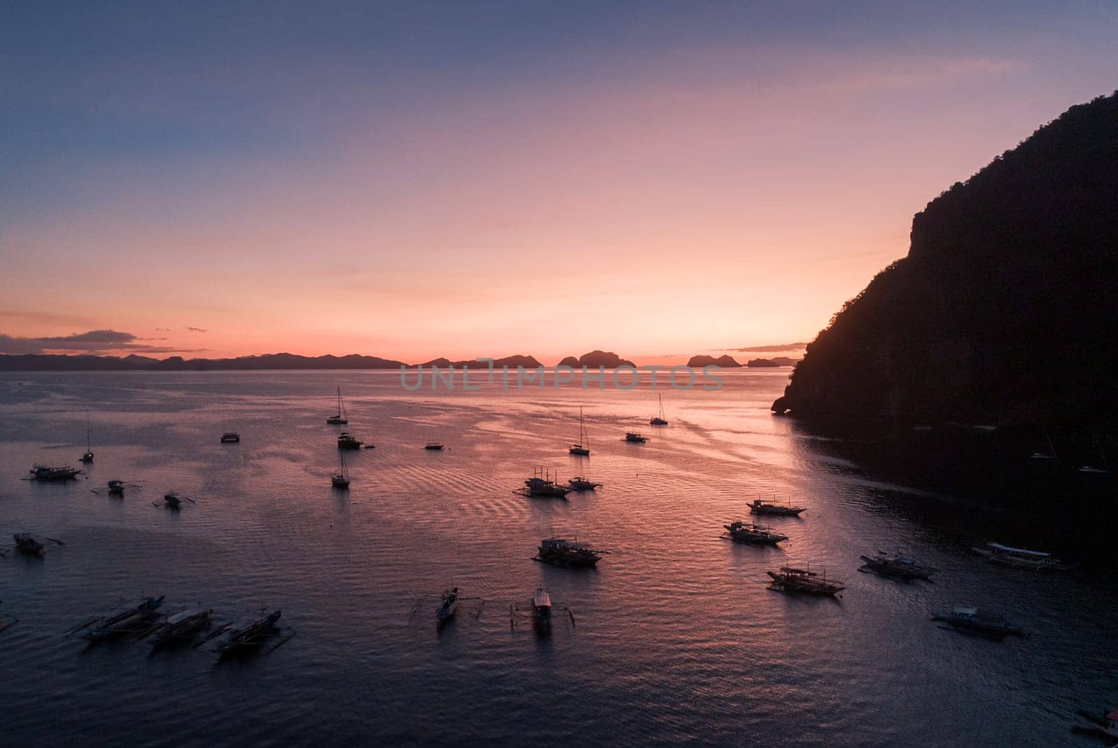 Aerial view of boats and yachts in the tropical bay on the sunset. El Nido, Palawan, Philippines. Travel concept. by Busker